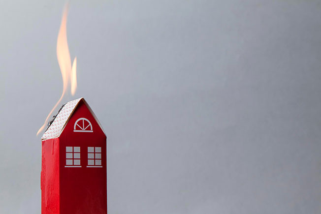 Model of a house with flames on the roof