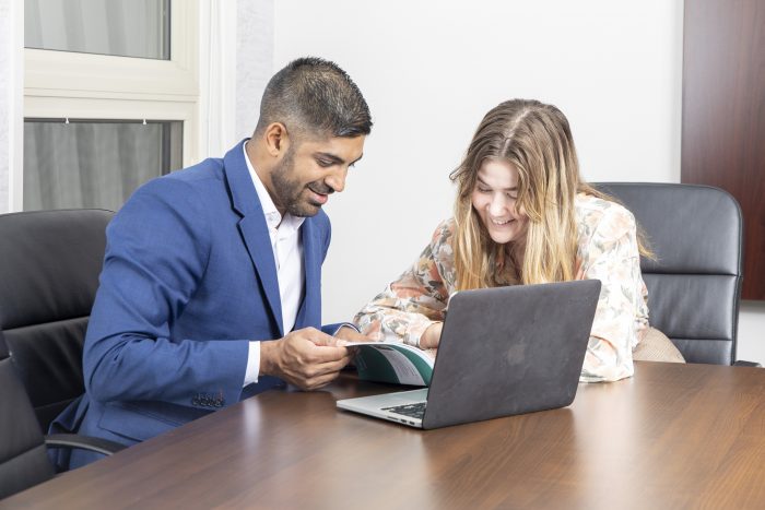 Fy Virani working in conference room with associate