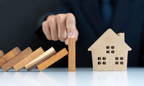 Wooden block representing property damage insurance protects a model house